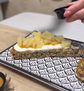 Porción de tortilla con yogur, ananá y un hilo de miel